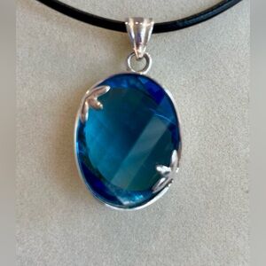 Faceted blue topaz and silver pendant. 1” long. NEW